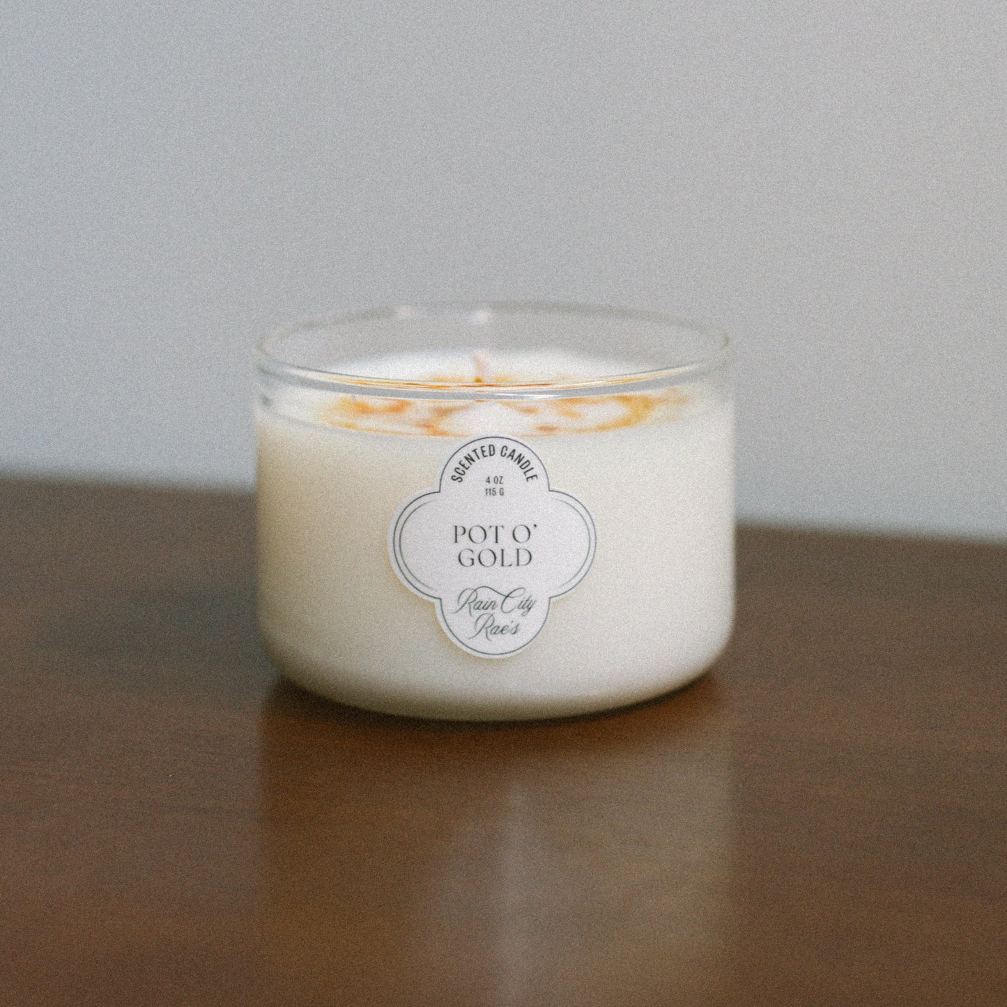 Pot of Gold Candle for St Pattys Day on a wooden surface and gray background