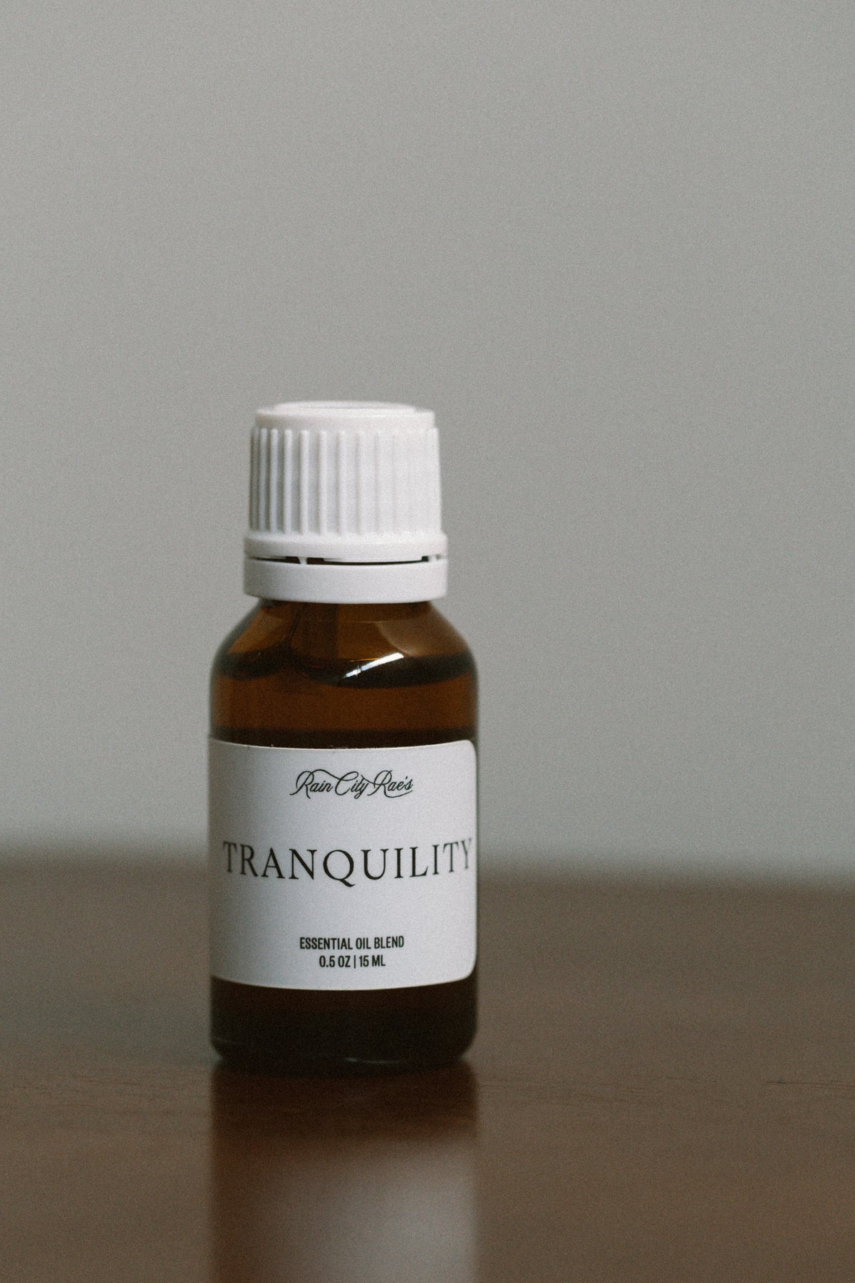 Bottle of Tranquility essential oil blend on a neutral background