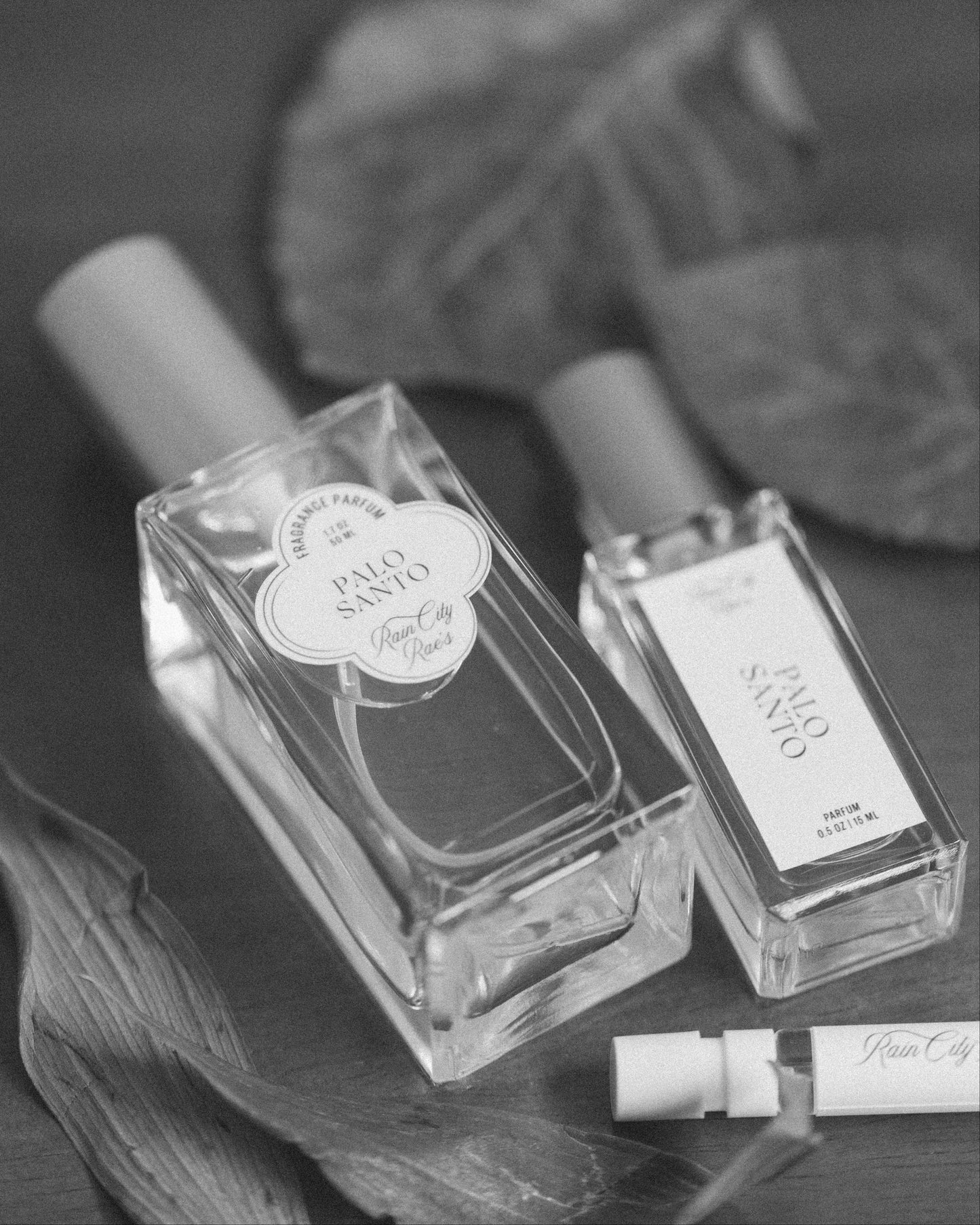 Two Palo Santo perfume bottles in 50 ml and 15 ml sizes black and white with 2 ml tester sprays