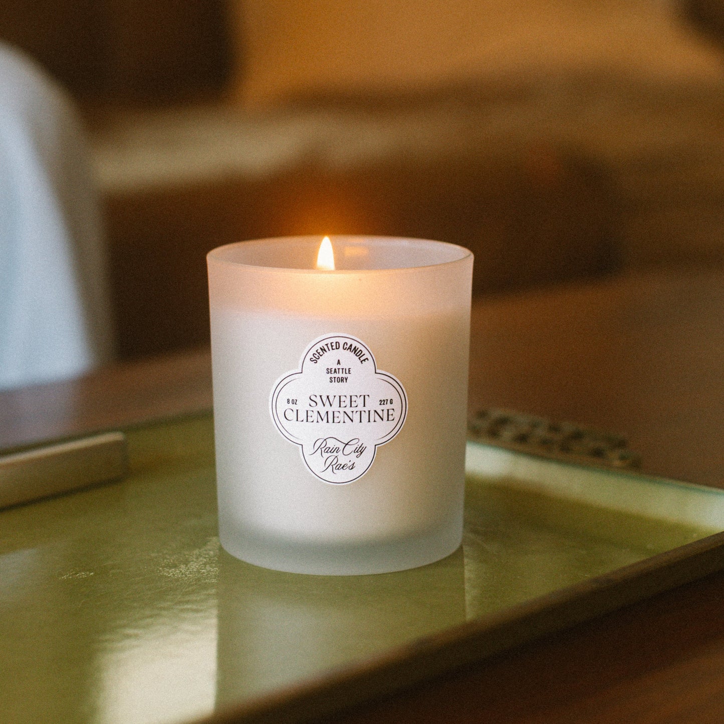 Candle on a table with a blurred background of a living room.