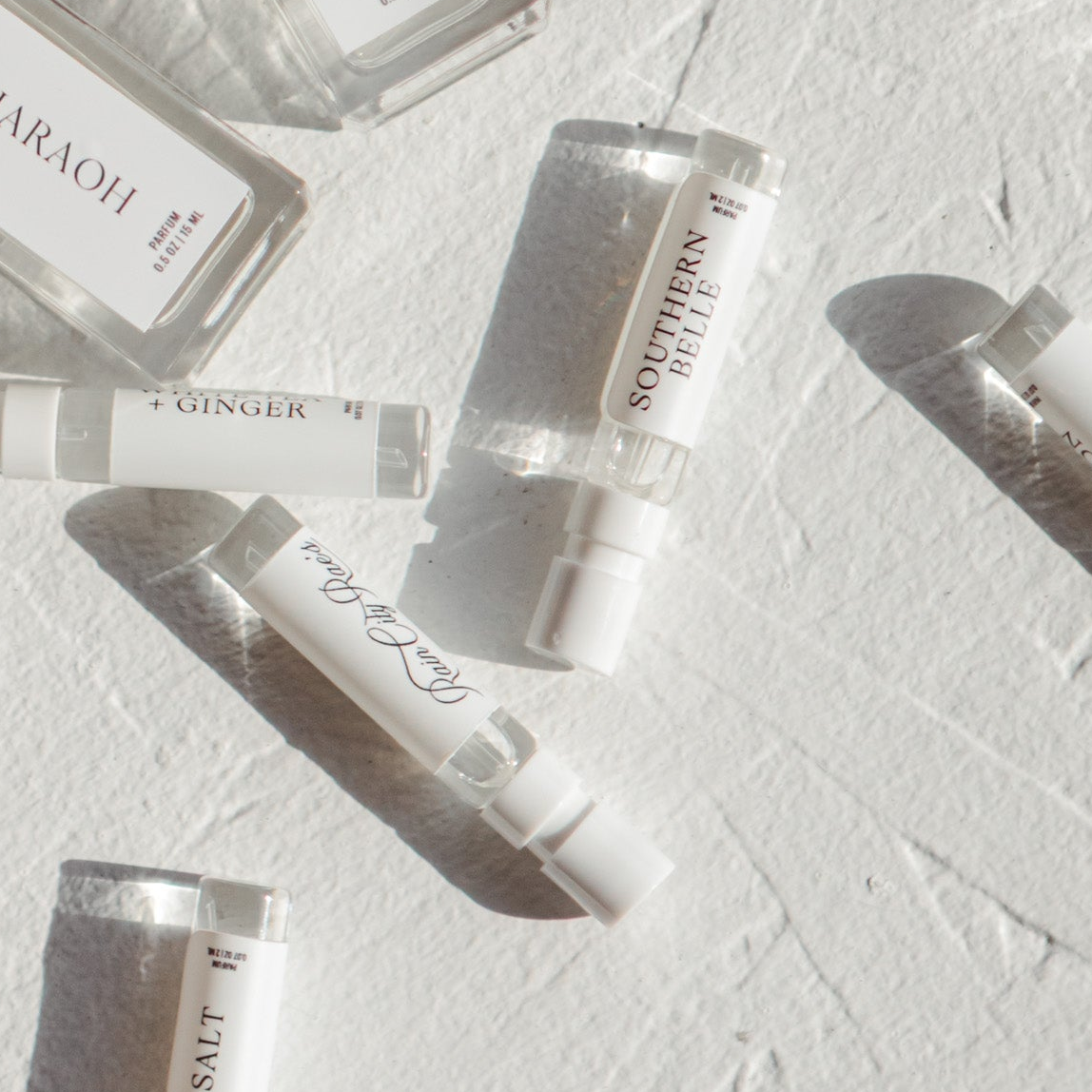 Set of perfume bottles on a textured white surface